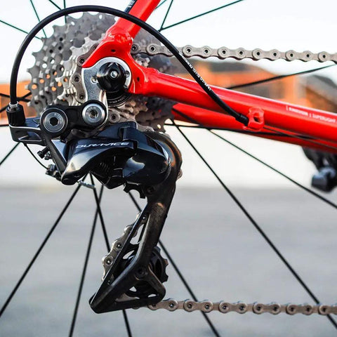 Close-up of rear derailleur with All In One Universal Bike Cable Replacement Kit for Shifting and Braking on road bike.