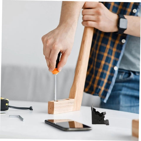 Close-up of installing Veemoon folding hinge on wooden table leg; orange screwdriver and black hinge visible.