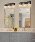 Two Light Black Industrial Vanity Light Sconces With Clear Glass Shades above bathroom mirrors