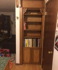 Slick Bookshelf Hidden Door Hinge System DIY Kit For Man Cave And Play Room Stealthy Stash Spot with shelves and wooden frame.