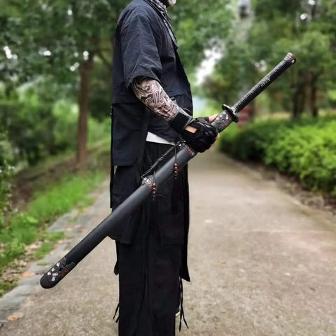 Person holding Hand Forged Longquan Style Dao Sword With High Carbon Steel Blade Full Tang And Dope Matte Black Wooden Scabbard