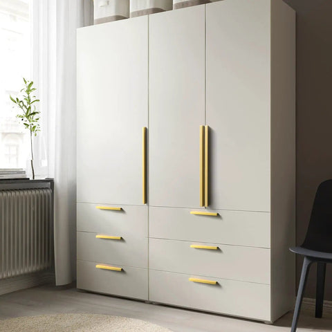 12 Pack Light Brushed Brass Tilted Drawer Pulls for Cabinets, Solid Aluminum Alloy Finger Pull Handles on a white double-door wardrobe