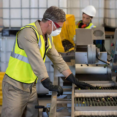 Worker wearing safety gear operates machinery in a factory setting