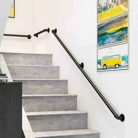 Adjustable Step Handrail For Indoor Outdoor Stairs, Heavy Duty Wrought Iron Wall Banister, mounted on cement wall beside gray stairs.