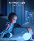 Baby next to glowing touch lamp multicolor night light for kids in bedroom, small LED table lamp for safe ambient lighting.