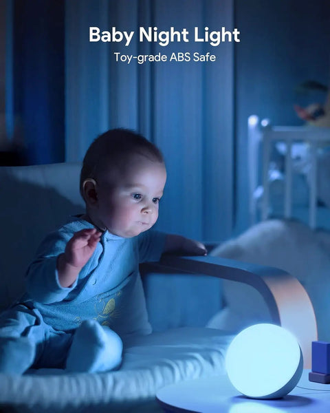 Baby next to glowing touch lamp multicolor night light for kids in bedroom, small LED table lamp for safe ambient lighting.