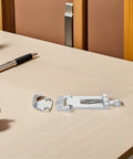 Stainless steel toolbox latch set, two-piece with anti-rattle mechanism, resting on a light wooden desk