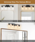 Top Shelf Four Light Bathroom Vanity Fixture With Slick Matte Black Frame And Knockout Clear Glass Shades Prime Wall Sconce Over various size mirrors.