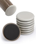 Heavy Duty Furniture Glides And Movers Pads With Strong Self Adhesive Backing, circular pads in a stack plus one from below.