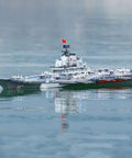 Dual-Motor 30 Km/H RC Battleship with Waterproof Hull on water surface, showcasing sealed cabin and remote control features.