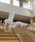 Sculptures of white animals on staircase in a modern interior space