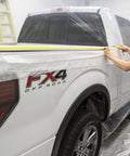 Man applying Pre Taped Masking Film With Three Quarters Inch Tape For Auto Body Protection to truck in paint booth