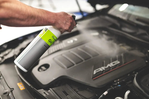 Person using All In One Car And Workshop Universal Cleaner Highly Concentrated And Dilutable on car engine in a workshop setting.