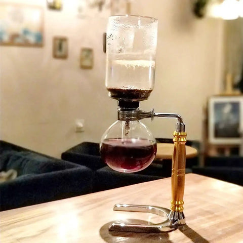Straight Fire Borosilicate Glass Siphon Coffee Maker With Heavy Duty Stainless Base And Precision Alcohol Burner For Smooth Cold Brew And Iced Coffee Vibes Tabletop Ready on wooden surface.
