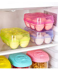Colorful plastic egg containers on fridge shelf, similar to Six Grid Egg Storage Box For Refrigerator And Camping, BPA-Free PP Material.