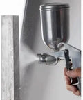 Pneumatic Paint Spray Gun With 400ML Aluminum Cup delivers a fine mist for coating, featured alongside a wooden surface.
