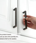 Hand holding Oil Rubbed Bronze Solid Square Kitchen Cabinet Handle 5 Inch on white cabinet door, easy install hardware