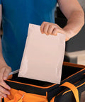 Man holding Khaki Poly Mailer Bags 100 Pack For Clothes And Cosmetics Easy Seal Tough Durable Poly Mailing Envelopes.