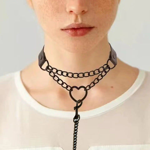 Dope Love Heart Choker Necklace Crafted From Thick Vinyl Leather Collar With Soft Plush Velvet Lining Adjusts Easily For Necks Up To Fifteen Inches Stacks Well With Body Chains For A Badass Gothic Vibe worn on a model.