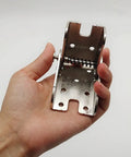 Big League Heavy Duty 90 Degree Folding Self Locking Furniture Hinge In Dark Bronze Galvanized Iron Support Bracket held in hand.