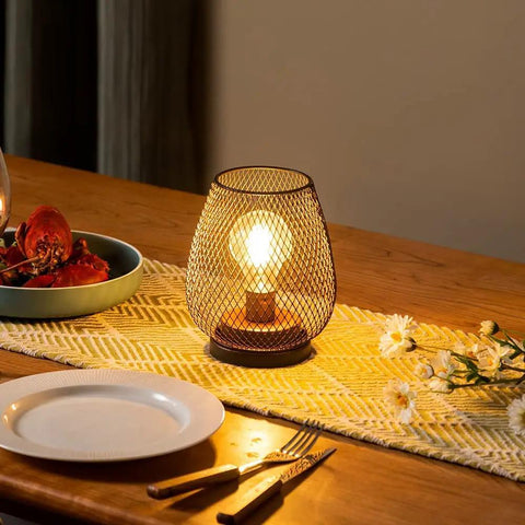 Set Of 4 Battery Operated LED Table Lanterns In Rustic Brown Metal Cage on a dining table