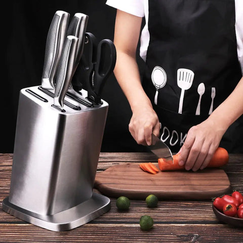 Six Slot Stainless Steel Kitchen Knife Block Holder With Tilted Slots And Angled Edges on wooden table with knife and carrots