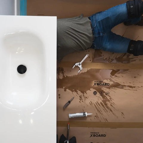 Installer working over X Board Paint and Remodel Surface Protector Heavy Duty Breathable Floor Shield 35 Inch by 100 Feet Roll