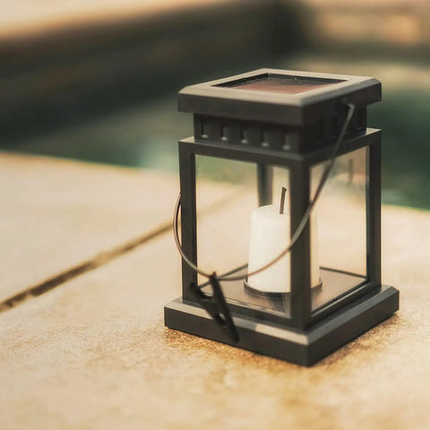 Close-up of a single lantern from the 8 Pack Solar Hanging Lanterns Outdoor With Candle Effect Warm White Light, by a poolside.