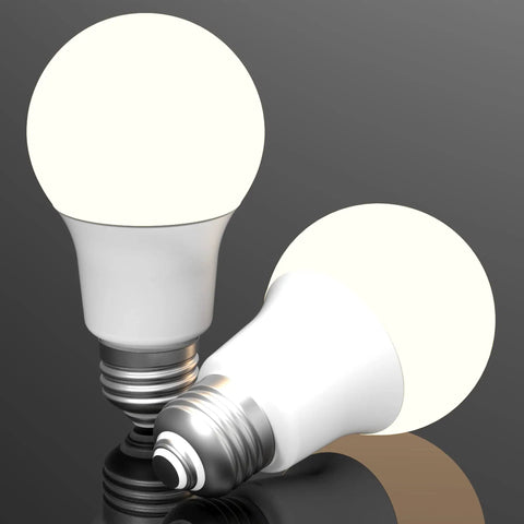 Two Three Way A19 LED Light Bulbs, 40 60 100 Watt Equivalents, E26 Socket, glowing on a reflective surface