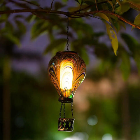 Lit Hot Air Balloon Solar Lantern With Flickering Flame Light, Tie Dye Glass Outdoor Lamp glowing in garden at night