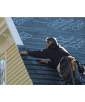Worker installing Rock Solid Self Adhering Ice And Water Shield Roof Underlayment 36 Inch By 66.6 Feet on sloped roof.