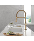 Pro Level Commercial Spring Neck Kitchen Faucet With Magnetic Docking Pull Down Sprayer Diamond Seal Tech Hella Smooth Handle Action In Champagne Bronze, shown on a kitchen sink.