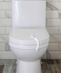 White toilet with child safety lock on lid in bathroom with tiled walls.