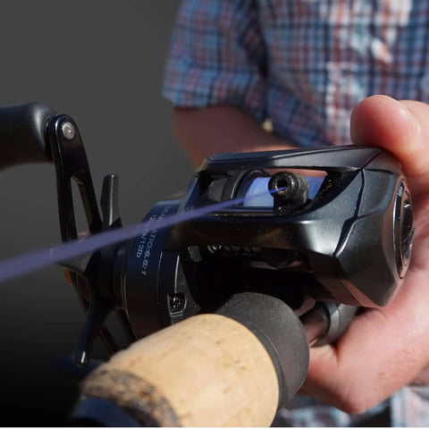 Vertix LP Baitcasting Reel Pro Grade Performance With 7 Plus 1 Ball Bearings, 20 Lb Carbon Fiber Drag in hand, dark gray.
