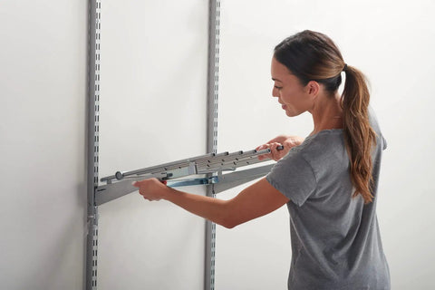 Woman installing Seven Pair Pants Rack For Closets In Titanium Finish With Non Slip Grippers And Slick Ball Bearing Glide
