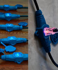 65 Feet Heavy Duty Extension Cord With 13 Evenly Spaced Outlets And Blue Indicator Lights, featuring illuminated outlets on wood and wall.