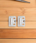 Two heavy duty stainless steel wall panel clips on wooden surface for drywall installation, part of 100 pack.