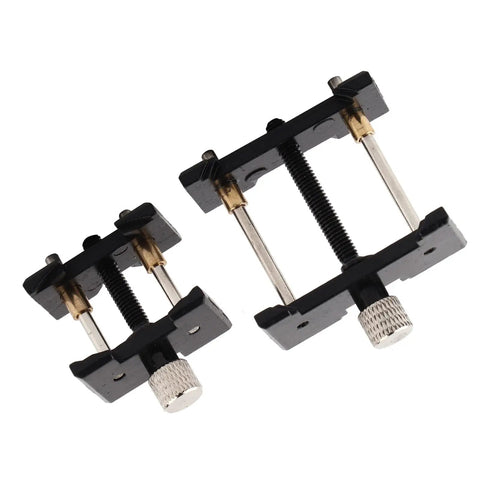 Two Piece Watch Movement Holder Kit With Non Slip Fixed Base And Plastic Repair Tool, black holders with metallic screws viewed from top