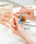 Hands using 40 Piece Stone Nail File Pumice Stick Set for Fingernails and Cuticles in a home manicure setting.
