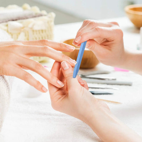 Hands using 40 Piece Stone Nail File Pumice Stick Set for Fingernails and Cuticles in a home manicure setting.