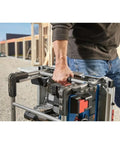 Heavy Hitter 18v Portable Table Saw 8 1/4 Inch Blade Bare Tool with rugged carry frame held by hand on job site.