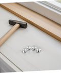 Heavy Duty Adjustable Furniture Levelers And Metal Screw Feet With Grippy Rubber Pads To Fix Wobbly Cabinets Tables Chairs And Dressers Zero Sweat Quick Install with hammer and silver feet on a table.