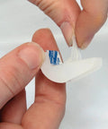 Peeling adhesive from a Self Adhesive Drawer Bumper Translucent 10 Pack for Cabinets and Rollout Shelves Protects Doors From Marring With Durable Plastic Peel And Stick No Screws Needed Optional Screw Attach For Extra Security.