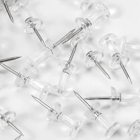 Legit Durable Push Pins 600 Count Standard Thumb Tacks With Kickass Steel Points And Clear Rounded Tops scattered on a surface.