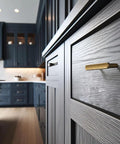 Close-up of Six Pack 3-Inch Classic Curvature Cabinet Handles in Antique Brass installed on dark wood kitchen drawer.