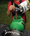 Person filling 35 lb green hopper of Lithium Ion Chest Spreader With Harness System, Adjustable Feed Rate, 24 Volt Power, Ideal For Seeding