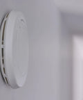Battery Powered Smoke Alarm P1210E with 10-Year Lithium Battery and Built-In Escape Light mounted on a wall
