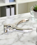 Hisxrcal T Shape Hole Punch Handheld Slot Cutter Tool For Card Name Tags Scrapbooking Projects on a marble table.