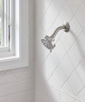 Five Function Shower Head With Three And Three Quarters Inch Spray Face Wall Mount In Spot Resist Brushed Nickel Finish on white tiles