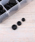 Premium Rubber Seal Ring Grommet Kit With 125 Black Grommets In Handy Plastic Storage Box For Faucets, Hoses, Electric Appliances And Fittings Elastic Heat Resistant Pollution Free Easy Replacement. Black rubber grommets in plastic storage box on wood